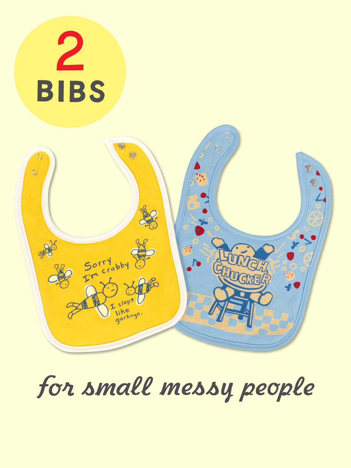 Two vibrant cotton bibs by Blue Q—one with “Sorry I'm Crabby. I Slept Like Garbage.” and the other with “Lunch Chucker”—are made of absorbent jersey and terry, labeled “2 bibs” and captioned “for small messy people.”.