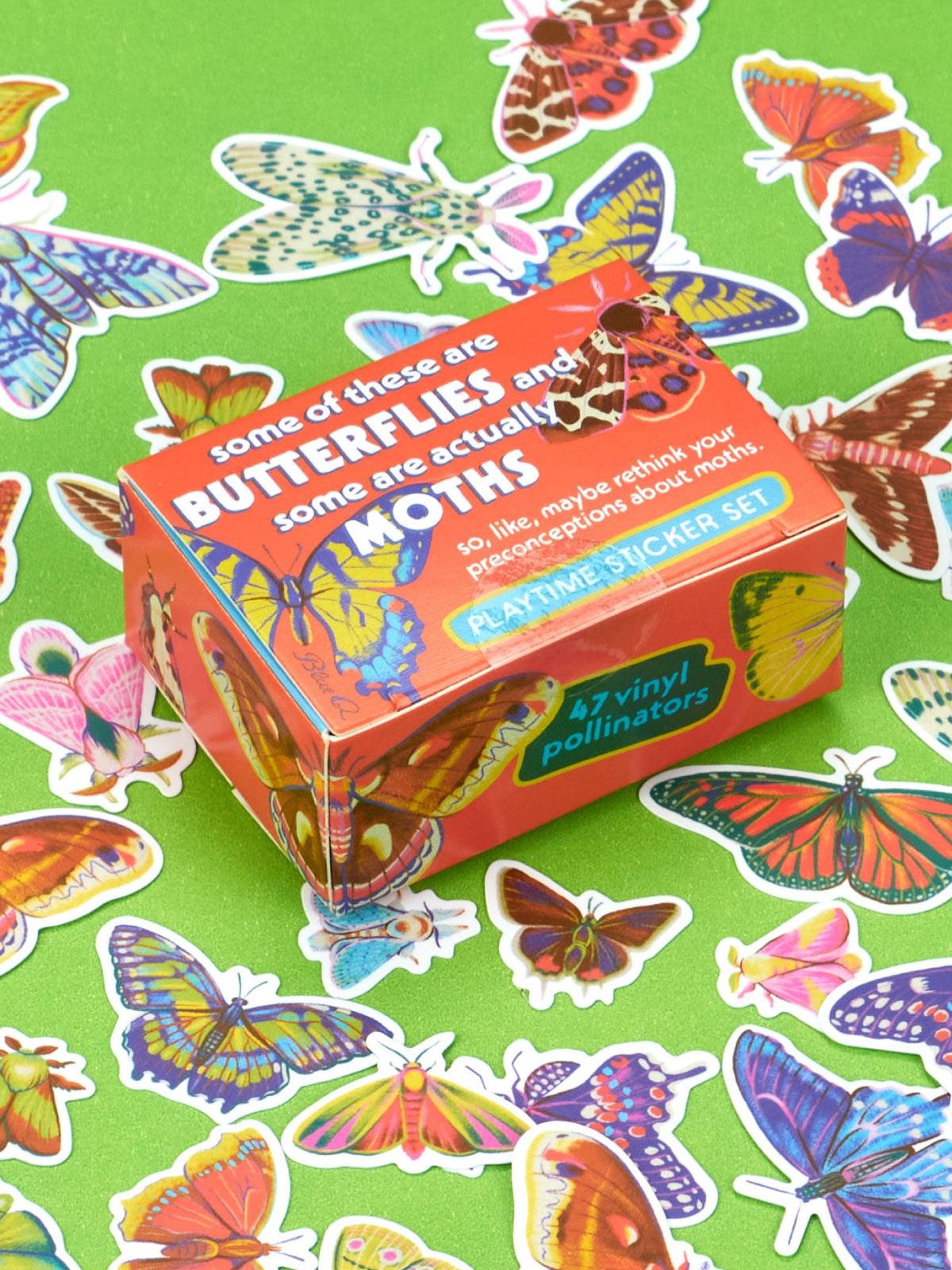 A Blue Q Some Of These Are Butterflies And Some Are Actually Moths Playtime Sticker Set featuring 47 vinyl butterfly and moth stickers surrounded by loose lepidopterans on a green background.