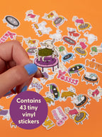 A hand holds a Baby Goats On Trampolines Wearing Sweaters Playtime Sticker Set goat sticker on a trampoline, surrounded by a collection of similar bouncing toy stickers on an orange background.