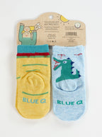 Blue Q's "I Love Your Face/If You Drop Me I'll Remember" baby socks: one yellow with green and red stripes, one light blue with a cartoon dinosaur, made from OCS certified organic cotton in packaging featuring a smiling illustrated character waving.