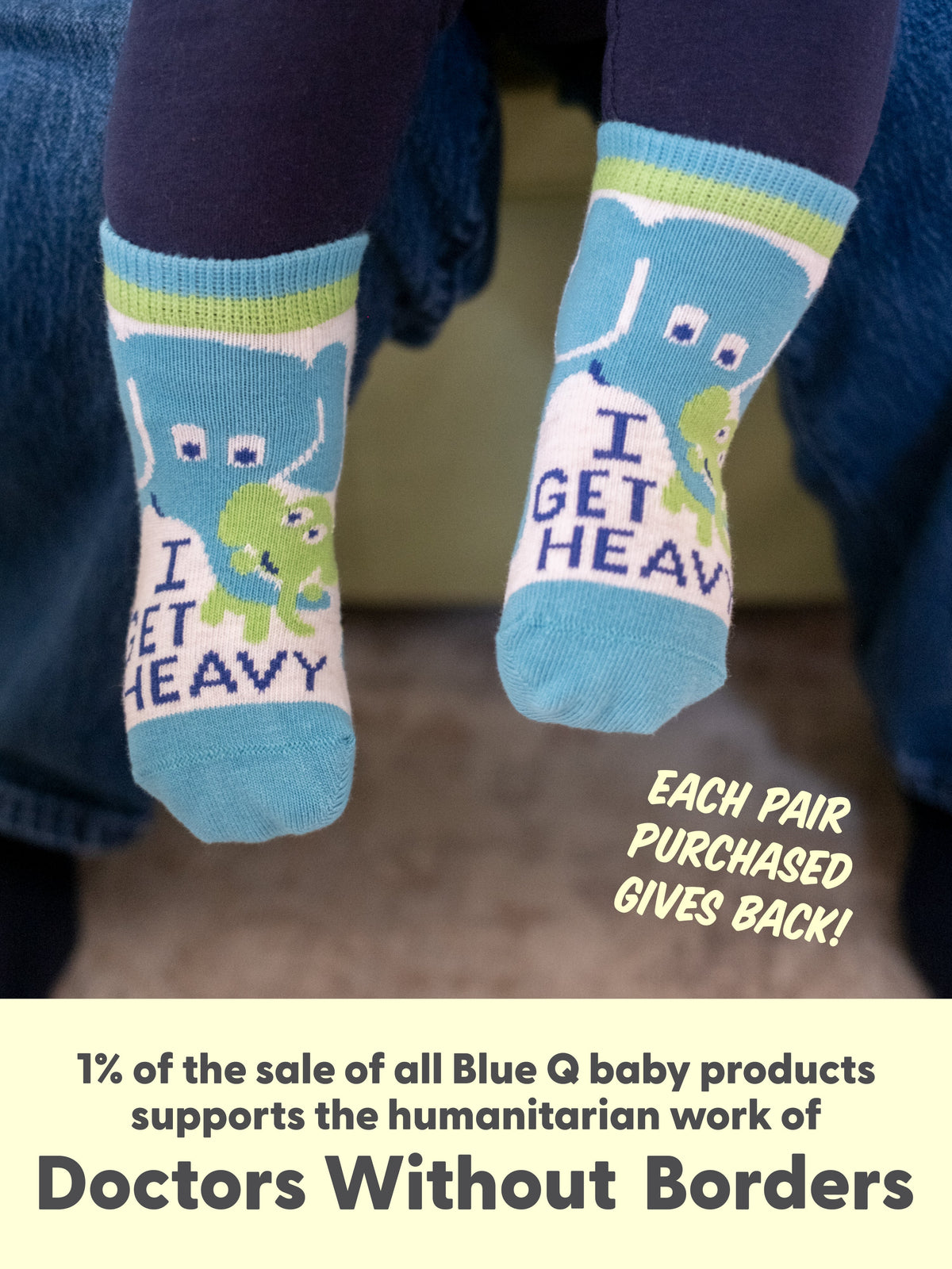 A baby wears Blue Q's Little Meatball/I Get Heavy cotton socks with cartoon elephants. Each pair gives back—1% of Blue Q baby product sales supports Doctors Without Borders.