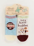 Blue Q Dog Lover Jr./Itty Bitty Buddies Baby Socks: set of 2 pairs for ages 0-12 months—one blue with "Dog Lover Jr." text, one white with cartoon dogs and "itty bitty buddies" design.